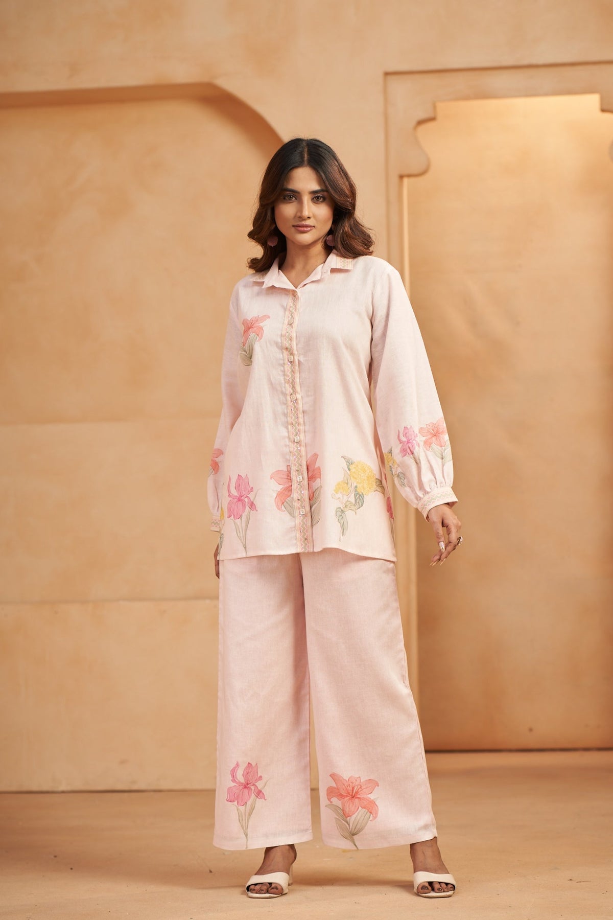 Woman wearing a light pink embroidered outfit 