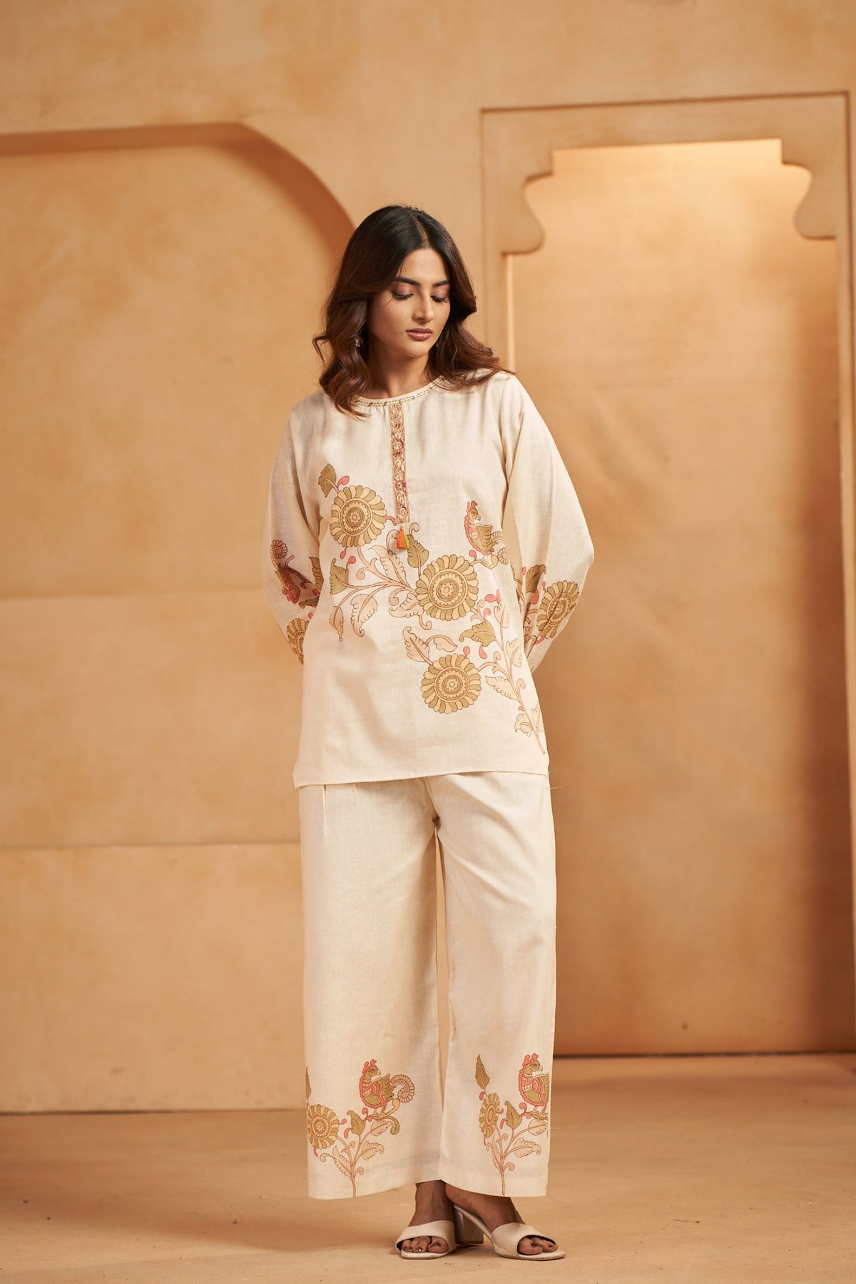 A woman wearing a cream-colored linen embroidered 
